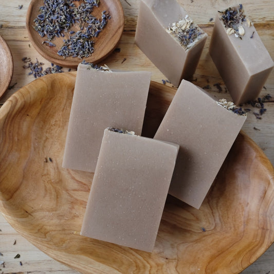 Stacks of Luna coconut milk soap bars that are naturally colored with purple clay and scented with lavender essential oil.