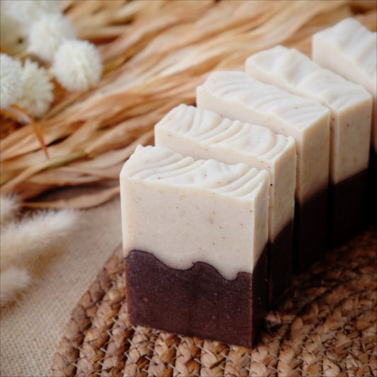 Two layered soap bar with a decorative pattern on a woven surface.