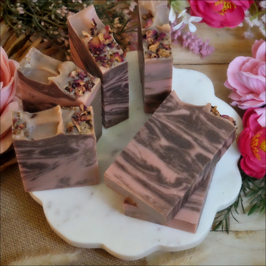 pink and brown swirled soap bars on white plate surrounded by florals