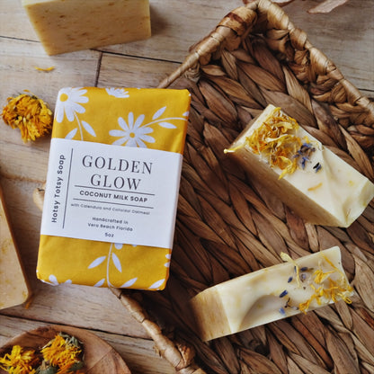 Golden Glow coconut milk soap is naturally scented with Lemongrass and lavender and naturally colored with calendula petals, colloidal oatmeal and kaolin clay. Each soap is decorated with dried herbs and botanicals and is wrapped in bright yellow paper with white flowers.