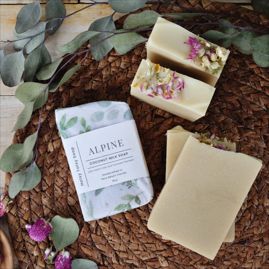 Creamy white bars of coconut milk soap scented with  peppermint, eucalyptus and cedarwood atlas essential oils. Naturally colored with colloidal oatmeal, kaolin clay and plant oils. Each soap is decorated with dried wild flowers and wrapped in white paper with green eucalyptus leaves.