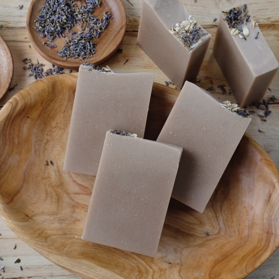 Stacks of Luna coconut milk soap bars that are naturally colored with purple clay and scented with lavender essential oil. 