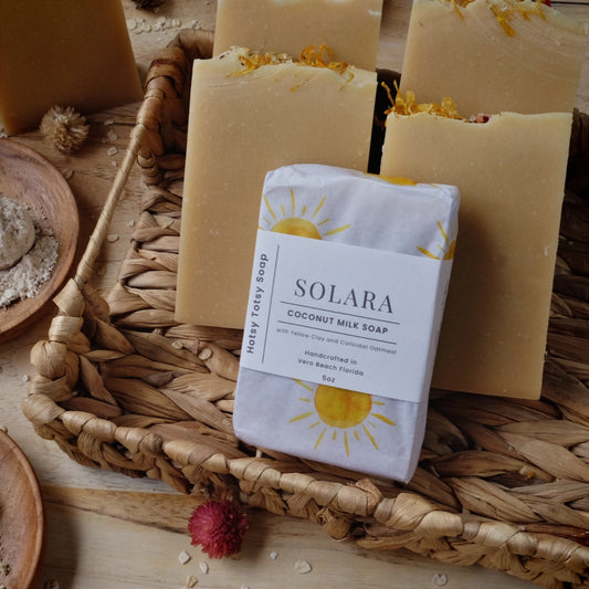 Golden coconut milk soap bars scented with lavender, litsea cubeba and geranium essential oils. Naturally colored with yellow clay, colloidal oatmeal and kaolin clay. Each soap comes wrapped in white paper with yellow suns and a cigar band label. 