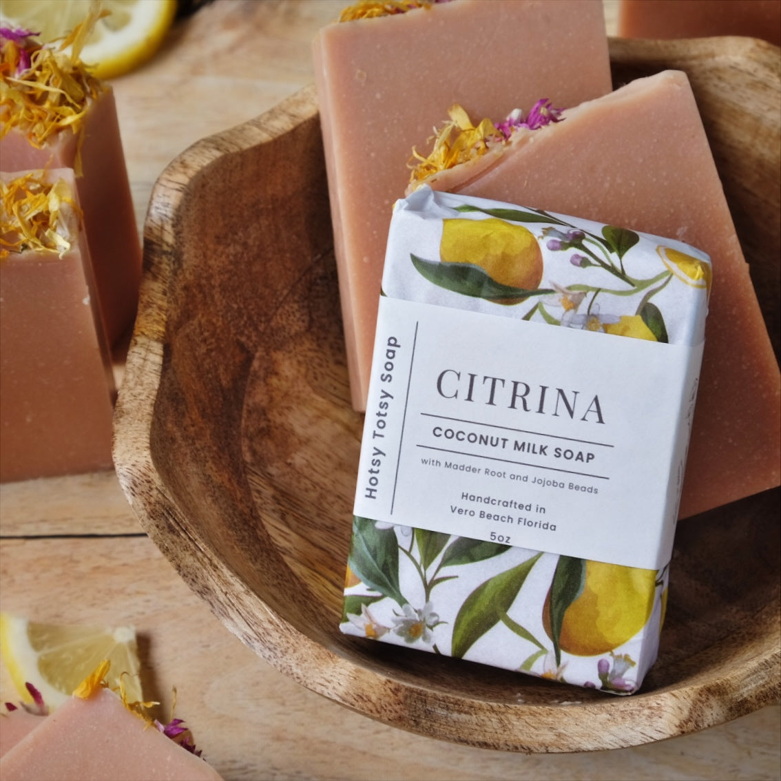 coconut milk soap bars naturally colored with French Pink clay. Scented with a blend of Bergamot, Litsea cubeba, and frankincense essential oils. Each bar is hand wrapped in decorative floral tissue with images of lemons and wrapped with a boutique inspired label. 