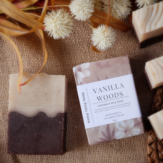 Bar of soap with 'Vanilla Woods' label on a textured surface with decorative elements.